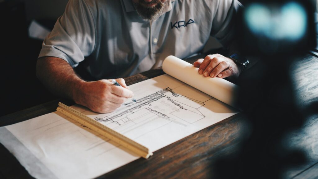 Arquitecto trazando planos sobre una mesa de dibujo